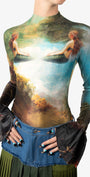 Long-sleeve top with artistic design of a woman in nature, paired with a denim skirt.