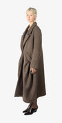A woman wearing a long brown coat