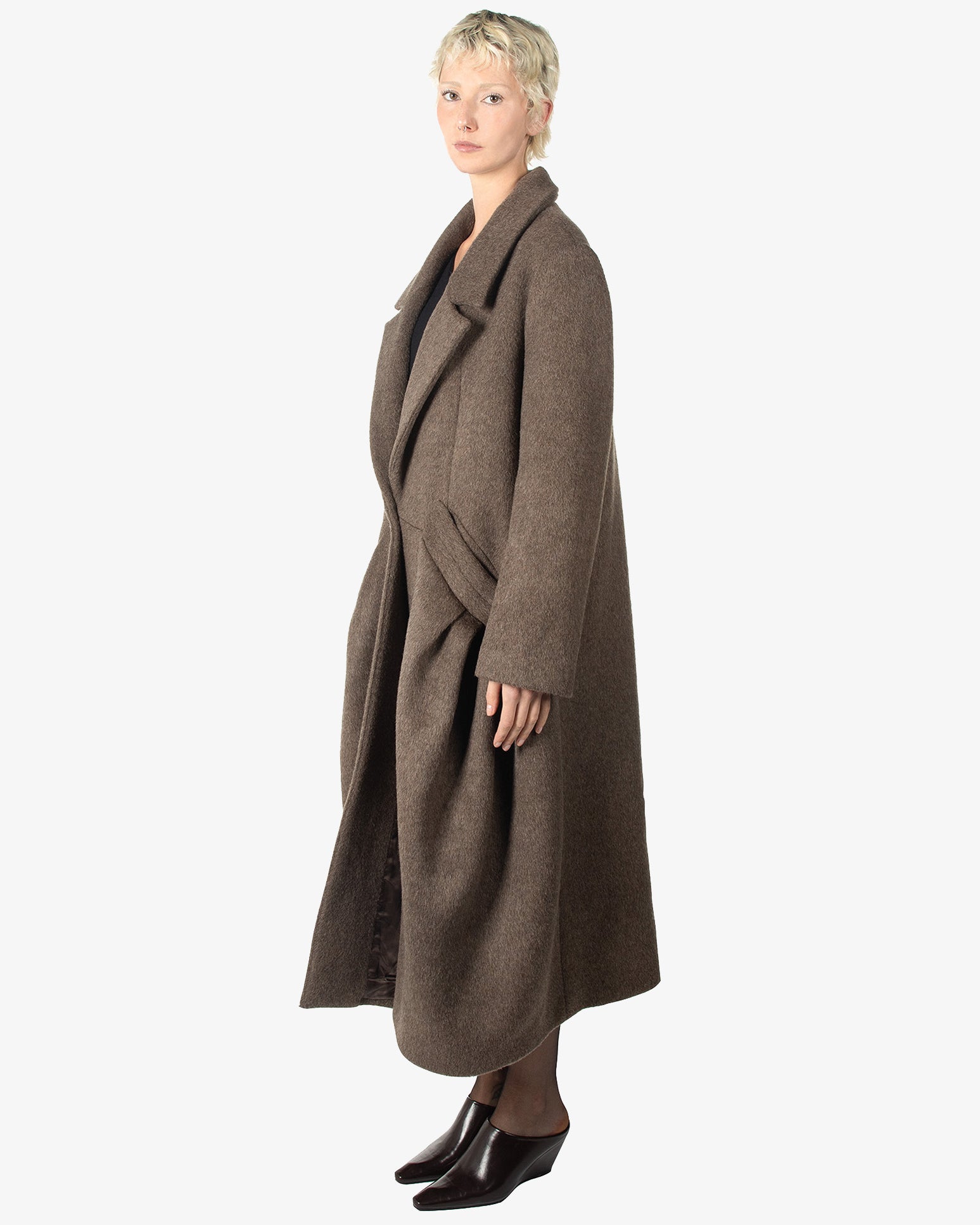 A woman wearing a long brown coat
